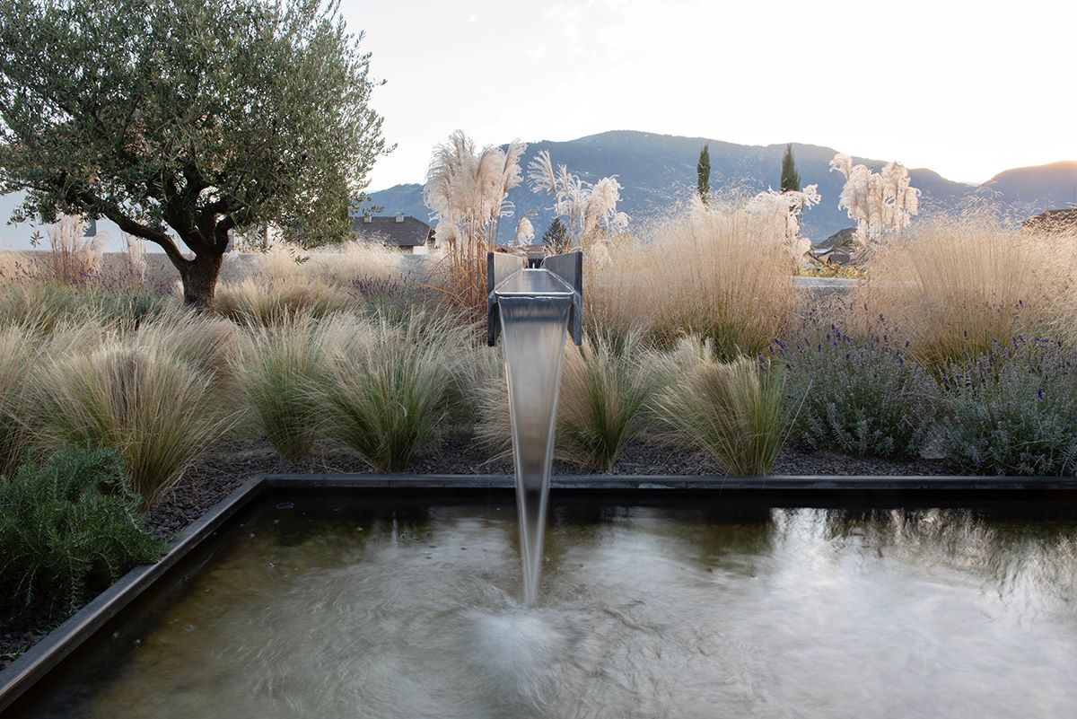 Vista esterna, lato nord, fontana e specchio d’acqua di Casa Visibilio in Trentino